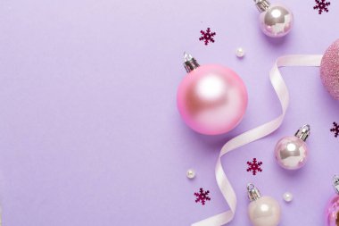Renkli arka planda dekoru olan pembe noel topları, üst görünüm