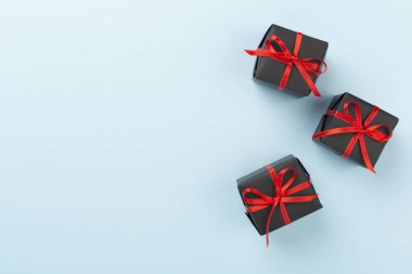 Renkli arka planda siyah hediye kutuları, üst görünümde. Kara Cuma konsepti