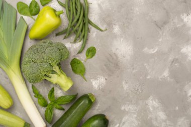 Ahşap arka planda farklı yeşil sebzeler.