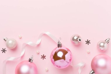 Renkli arka planda dekoru olan pembe noel topları, üst görünüm