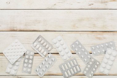 Kabarcık ambalajlı haplar ahşap arka planda, üst manzara