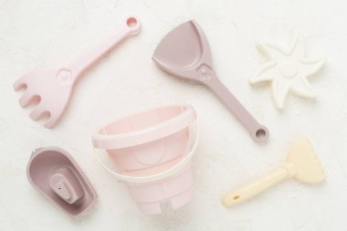 Beton arka planda kumla oynamak için sevimli oyuncaklar.