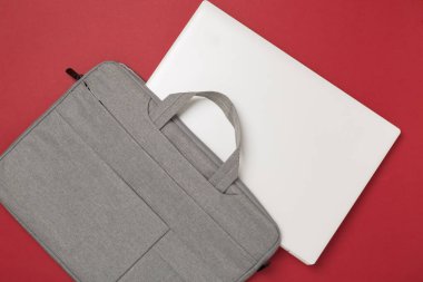 Renkli arka planda aygıtı olan gri renkli dizüstü bilgisayar çantası, üst görünüm