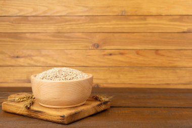 Tahta masada büyülenmiş tahıl ve kulaklarla kase