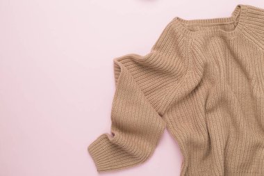 Renkli arka planda bej örülmüş süveter, üst görünüm