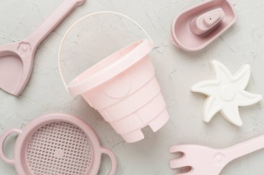 Beton arka planda kumla oynamak için sevimli oyuncaklar.