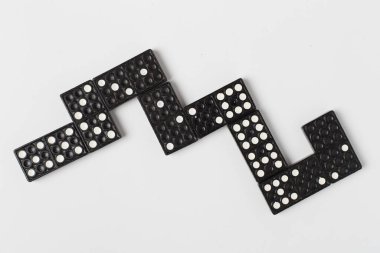Beyaz arkaplanda siyah domino taşları, üst görünüm