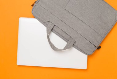 Renkli arka planda aygıtı olan gri renkli dizüstü bilgisayar çantası, üst görünüm