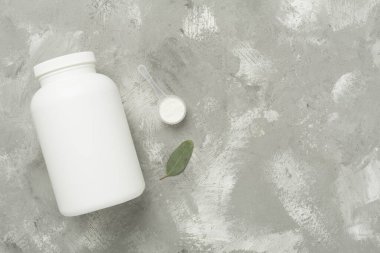 Beton zemin üzerinde protein tozu olan kavanozlar, üst manzara. Spor beslenme konsepti