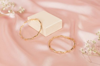 Arkaplanda dekoru olan altın küpeler