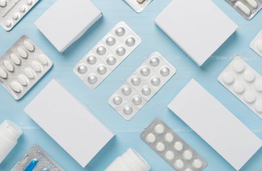 Su toplamada ve kutularda farklı haplar ve ahşap arka planda üst görünüm.