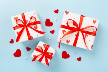 Renkli arka planda kırmızı kalpler olan hediye kutuları, üst görünüm