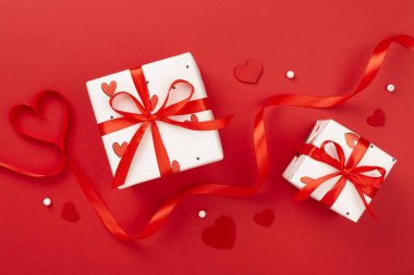 Renkli arka planda kırmızı kalpler olan hediye kutuları, üst görünüm