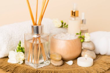 Tahta masa üzerinde frezya çiçeği ve aroma yayıcı içeren spa kompozisyonu