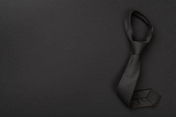 Черный галстук на цветном фоне, вид сверху