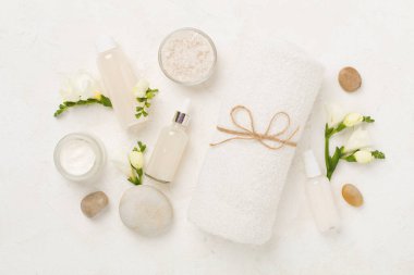 Tahta arka planda kaplıca ürünleri ve çiçeklerle yatıyordu