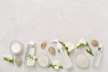 Tahta arka planda kaplıca ürünleri ve çiçeklerle yatıyordu