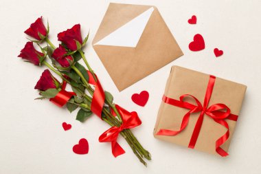 Beton arka planda hediye kutusu olan kırmızı gül çiçekleri, üst, manzara. Sevgililer Günü konsepti