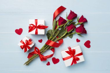 Ahşap arka planda hediye kutusu olan kırmızı gül çiçekleri, üst, manzara. Sevgililer Günü konsepti