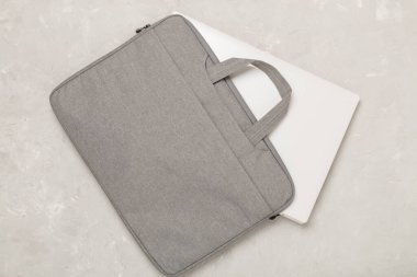 Ahşap arka planda aygıtı olan gri renkli dizüstü bilgisayar çantası, üst görünüm