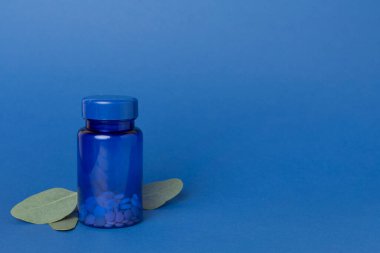 İlaç şişeleri ve yeşil yapraklar.