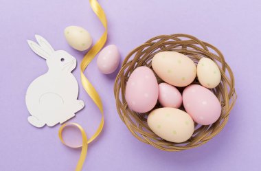 Renkli arka planda yumurtaları olan Paskalya tavşanı.