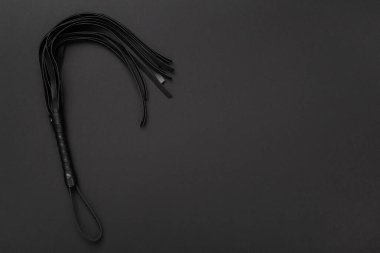 Renkli arka planda siyah kırbaç, üst manzara. BDSM konsepti