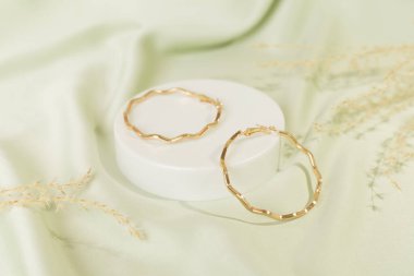 Arkaplanda dekoru olan altın küpeler