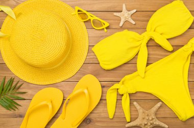 Tahta arka planda sarı yazlık kıyafetlerle yatıyordu. Tatil kavramı