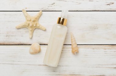 Ahşap arka planda yaz dekoru olan güneş kremi, üst görünüm