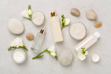 Beton zemin üzerinde spa ürünleri ve çiçeklerle yatıyordu