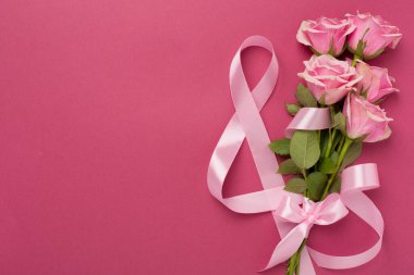 Pembe güllü kompozisyon, hediye kutusu ve arka planda sekizli kurdele, üst manzara. Kadınlar Günü konsepti