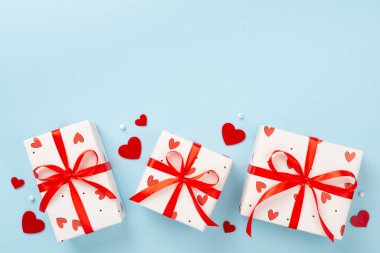 Renkli arka planda kırmızı kalpler olan hediye kutuları, üst görünüm