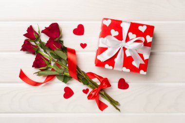 Beton arka planda hediye kutusu olan kırmızı gül çiçekleri, üst, manzara. Sevgililer Günü konsepti