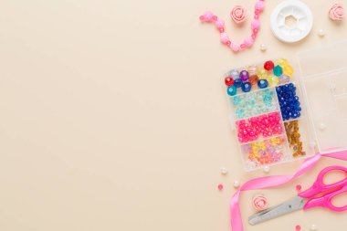 Renkli arka plan, üst görünüm üzerinde el yapımı mücevherler yapmak için araçlar ve boncuklar