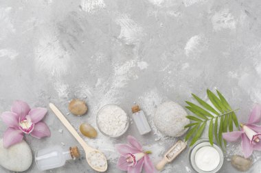 Orkideli kompozisyon, somut arka planda spa ürünleri, üst görünüm