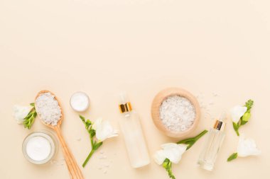 Renkli arka planda spa ürünleri ve çiçeklerle düz yatıyordu