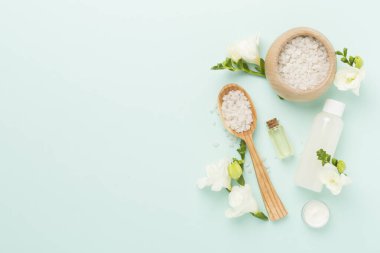 Renkli arka planda spa ürünleri ve çiçeklerle düz yatıyordu