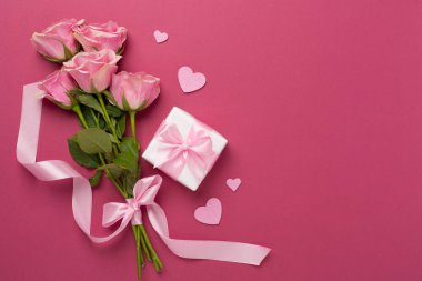 Kalpli pembe güller ve renkli arka planda hediye kutusu, üst manzara. Sevgililer Günü konsepti
