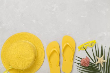 Beton arka planda sarı yazlık kıyafetlerle yatıyordu. Tatil kavramı