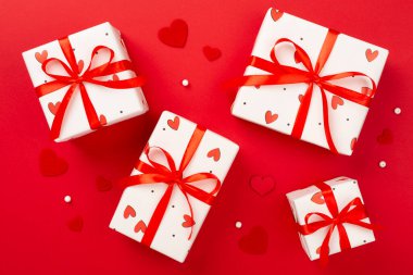 Renkli arka planda kırmızı kalpler olan hediye kutuları, üst görünüm