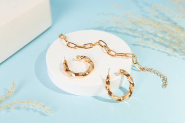 Arkaplanda dekoru olan altın küpeler