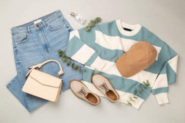 Gri arka planda kadınların moda bahar kıyafetleriyle yatıyordu.