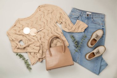 Gri arka planda kadınların moda bahar kıyafetleriyle yatıyordu.