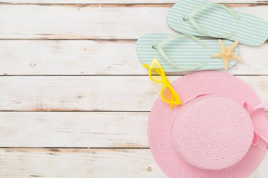 Ahşap arka planda renkli plaj aksesuarları olan düz bir yer. Tatil kavramı