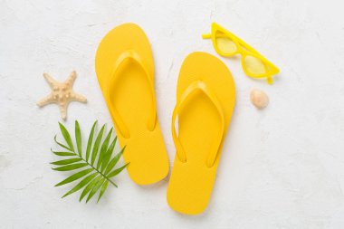 Beton arka planda parlak sarı parmak arası terlikler, üst manzara. Yaz konsepti