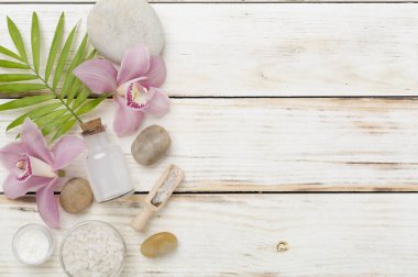 Orkideli kompozisyon, ahşap arka planda spa ürünleri, üst görünüm