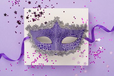 Renkli arka planda konfeti olan parlak karnaval maskesi, üst görünüm