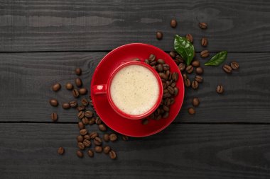 Kahve çekirdekli kahve ve ahşap arka planda yapraklar.