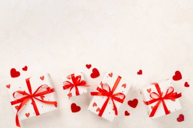 Beton zemin üzerinde kırmızı kalpler olan hediye kutuları, üst görünüm